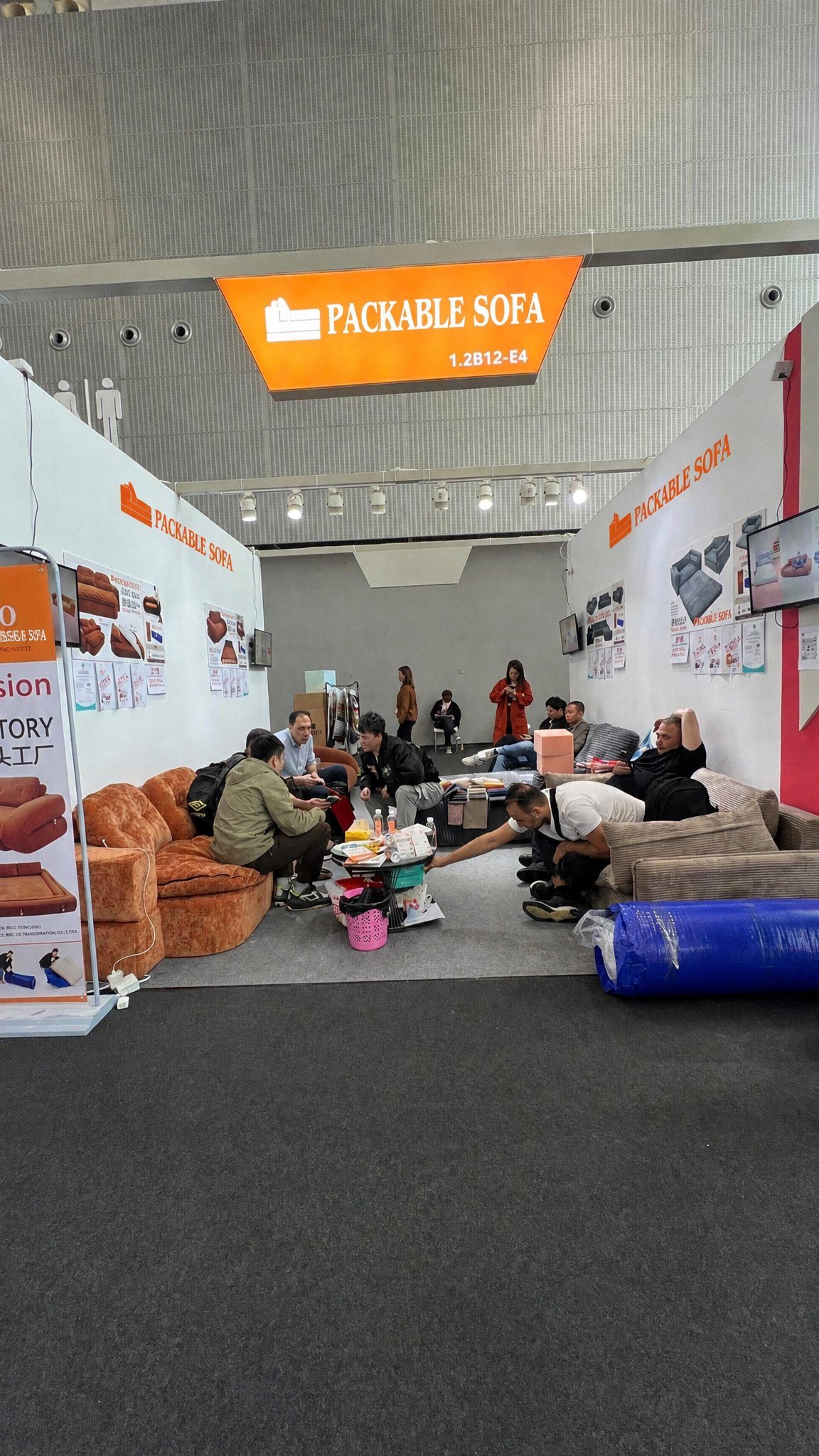 Visitors at a furniture trade-show booth