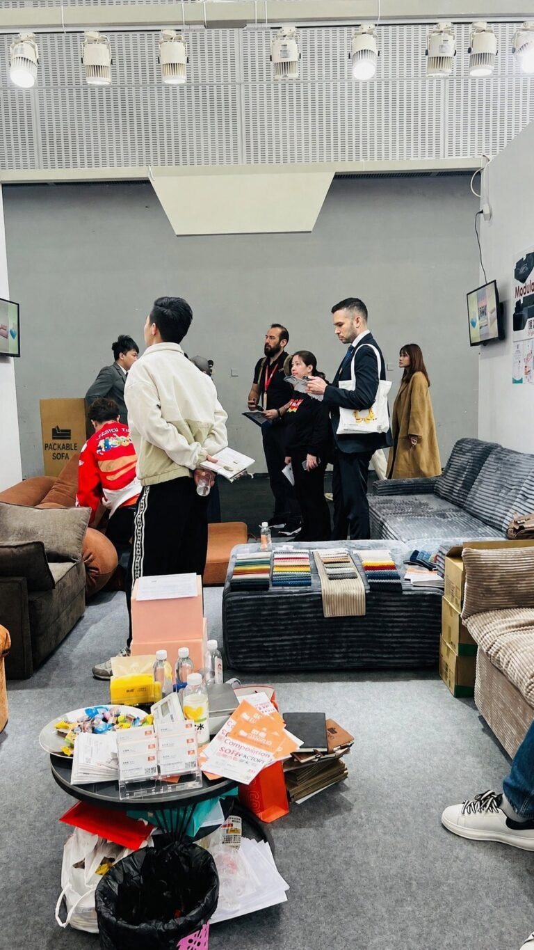 Visitors reviewing sofas and fabric samples at a trade show